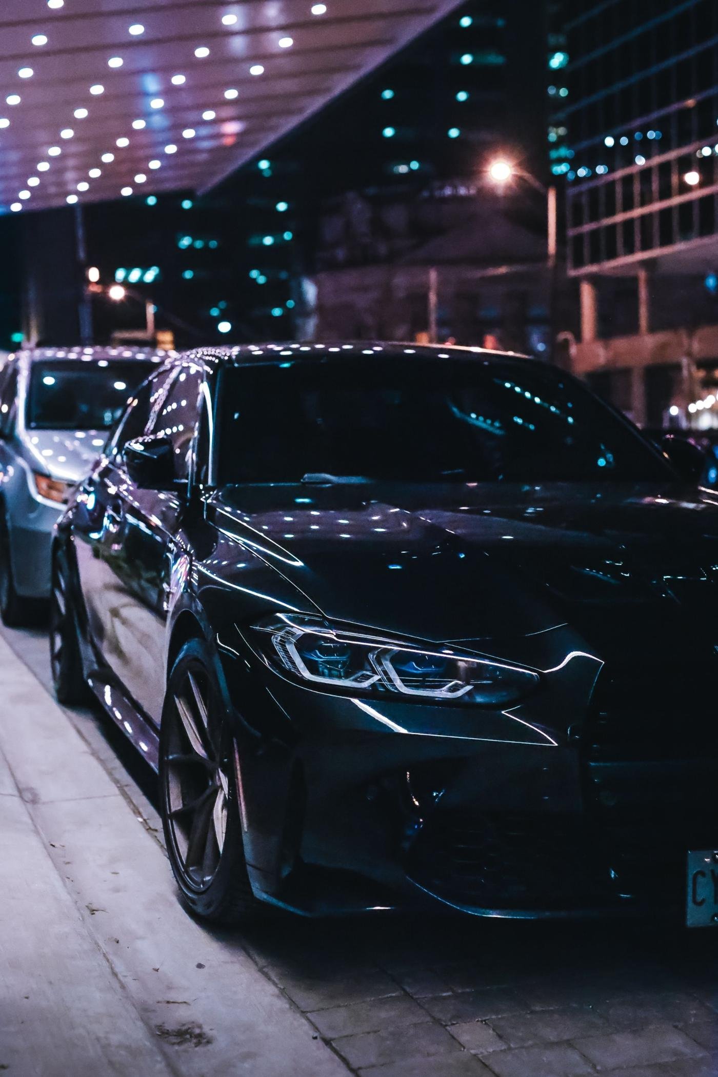 Melns BMW pēc virsbūves remonta un pulēšanas nakts pilsētā